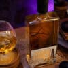 Savory bottle of traditional Serbian NDV Rakija, amber in color, on a cozy wooden table.