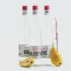 Clean glass rakija bottles with red caps and minimalist labels, accented by fresh pears.