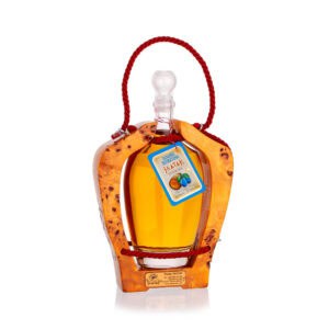 Decorative bottle of traditional fruit rakija in wooden holder, featuring NDV label and vibrant orange color.